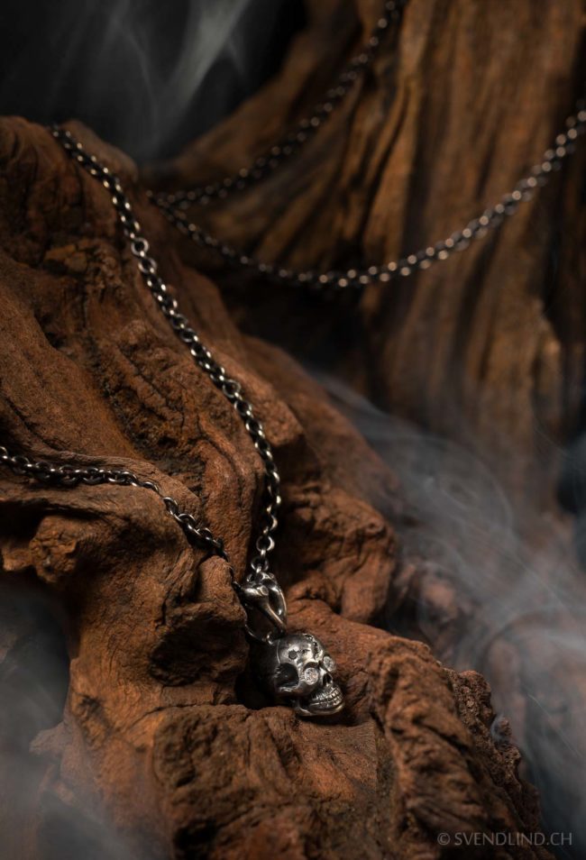 Skull pendant with diamonds on wood.